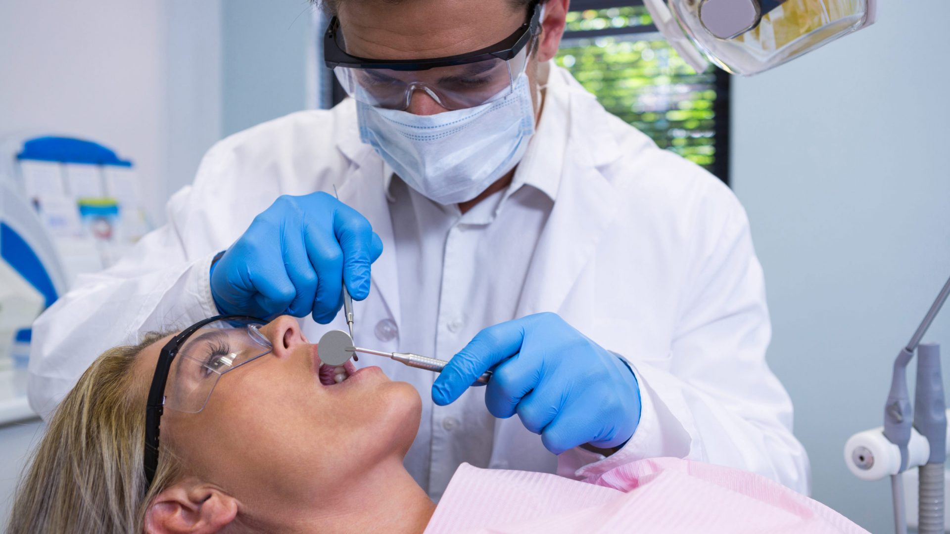 close-up-of-dentist-examining-woman-NA9M8WQ